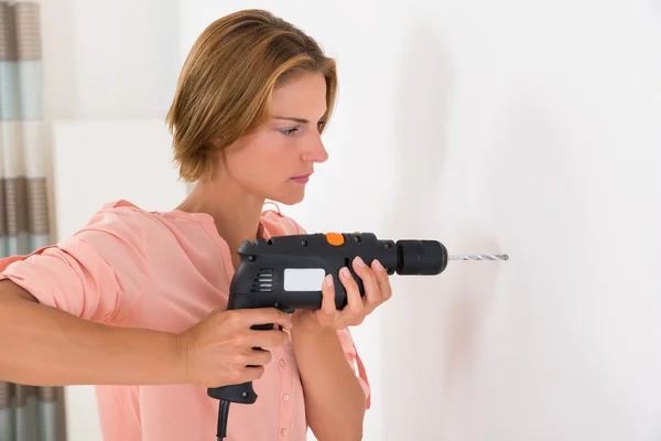 Mulher fazendo buraco com máquina de broca — Fotografia de Stock