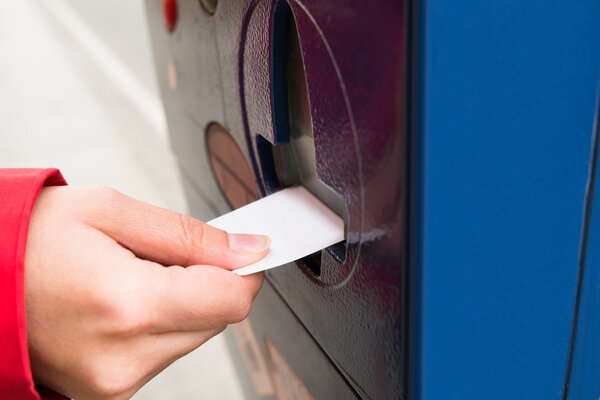 Person Hands Inserting Ticket Into Parking Machine