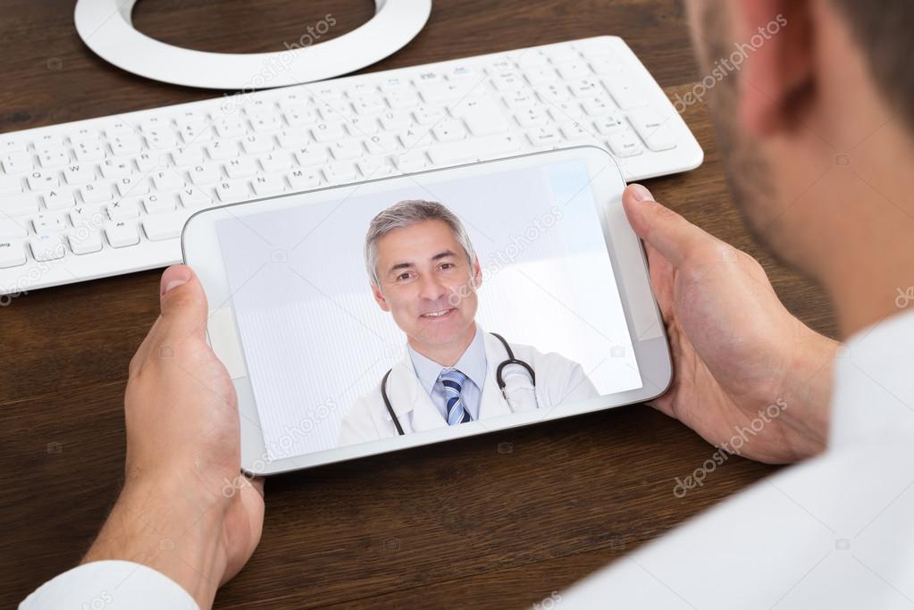 Businessperson Videochatting With Senior Doctor