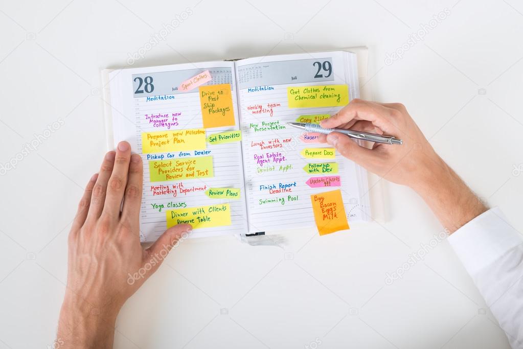 Businessperson Writing Note In Diary