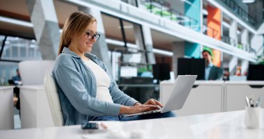 Finansal Analist Kadın Şirket Ofisinde Dizüstü bilgisayardaki Hisseleri Analiz Ediyor