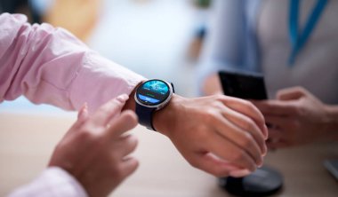 Kadın mağazada akıllı saat cüzdanı uygulaması kullanıyor..