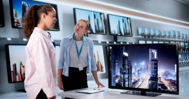 Meşgul Elektronik Mağazasında Akıllı Televizyon Modelleri Karşılaştıran Genç Kadın.