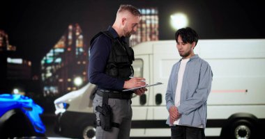 Sürücü, gece araba kazasından sonra sigorta polisiyle konuşuyor..