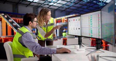 Lojistikte Verimli Otomasyon: Envanter yazılımıyla ticaretin geliştirilmesi, bir erkek ve kadının bilgisayar kullanmasını sağlıyor