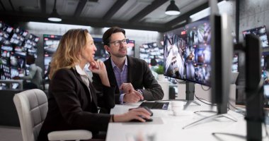 Güvenlik görevlisi ve operatör kontrol odasındaki güvenlik kamerası görüntülerini izliyorlar.