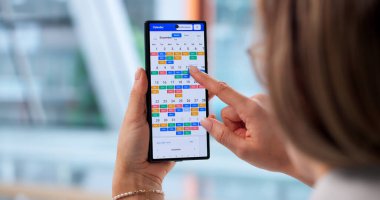 Takvim ve Kitap Toplantılarını Yönetmek İçin Akıllı Telefon Kullanmakla meşgul İş Kadınları