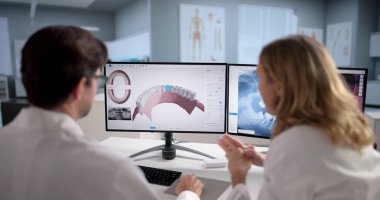 Yetenekli kadın dişçi diş hastalığını teşhis etmek için bilgisayar kullanıyor.