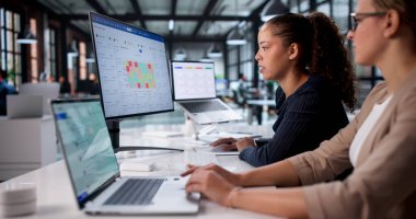 Ofisteki Dizüstü bilgisayardaki Kadın Veri Analisti Haritayı Analiz Ediyor.