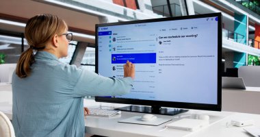 Ofisteki Sanal Toplantı sırasında Çoklu Ekranları Yönetmekle meşgul İşkadını.