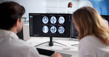 Erkek Nöroloji Uzmanı MRI Beyin Taramasını Gelişmiş Bilgisayar Teknolojisi Kullanarak İzliyor.