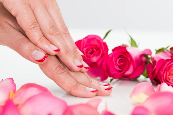 Close-up de mãos de mulher com rosas — Fotografia de Stock