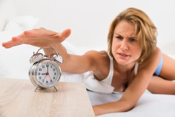 Mujer apagando el despertador —  Fotos de Stock