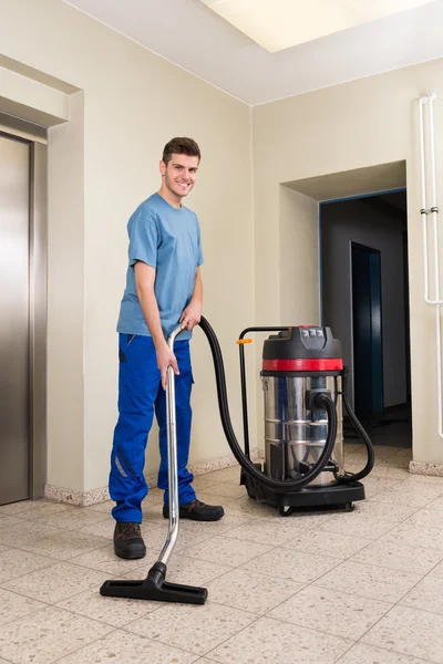 Männliche Arbeiter putzen mit Staubsauger — Stockfoto