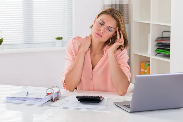 Frau mit Nackenschmerzen am Schreibtisch — Stockfoto