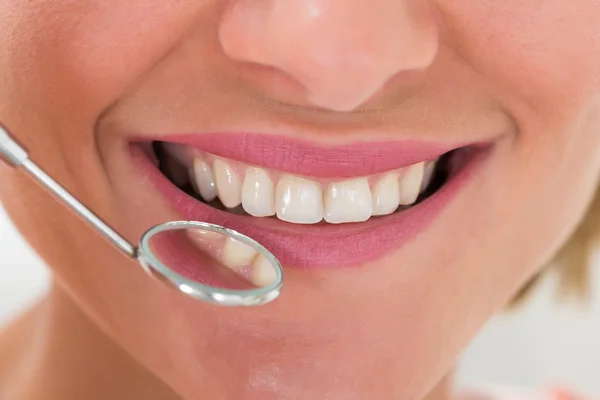 Mulher com dentes e espelho dentário — Fotografia de Stock