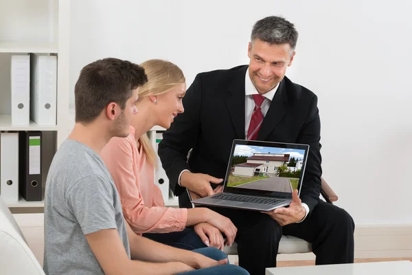 Agent Showing House On Laptop To Couple — Stock Photo, Image