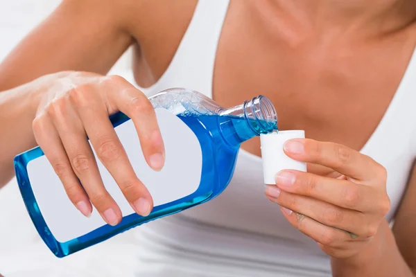Woman Pouring Mouthwash Into Bottle Cap — Stock Photo, Image