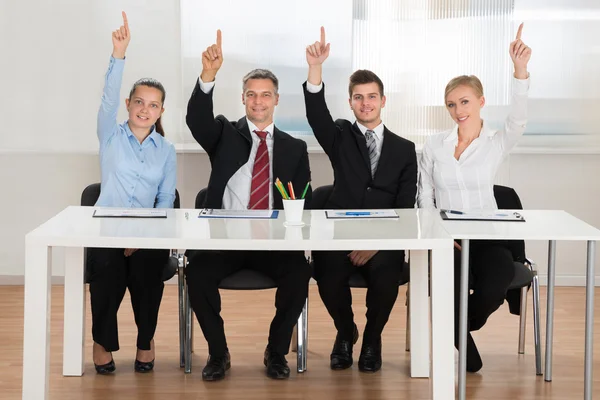Empresários levantando as mãos em conferência — Fotografia de Stock