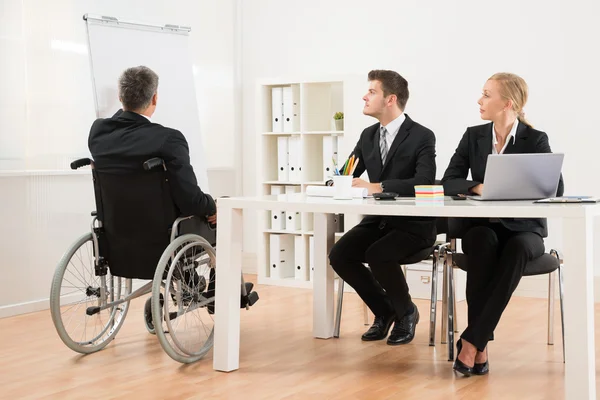 Behinderter Geschäftsmann erklärt seinen Kollegen — Stockfoto