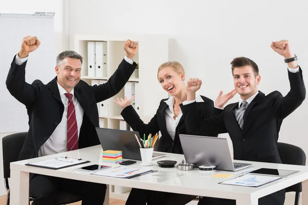 Empresários felizes com braço levantado no escritório — Fotografia de Stock