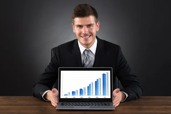 Бизнесмен показывает график на ноутбуке — стоковое фото