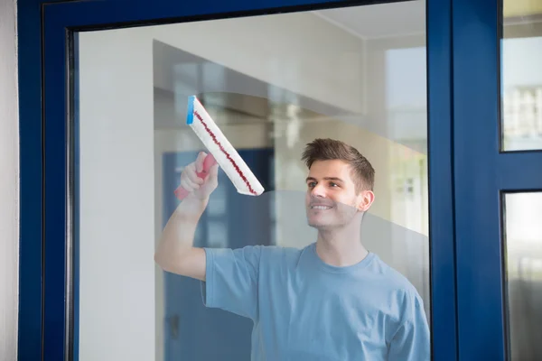 Vidrio de limpieza de trabajador con fregona —  Fotos de Stock