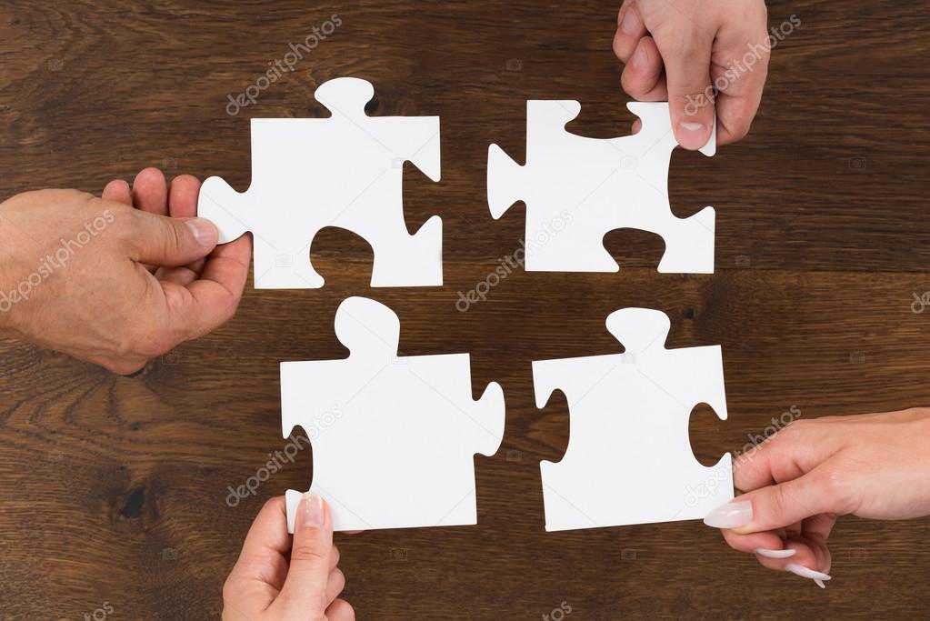 Human Hands Connecting Puzzle Pieces