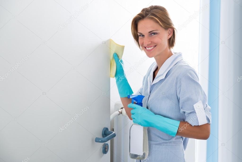 Young Maid Cleaning Door