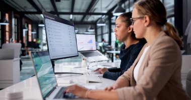 Mali İşler 'deki Kadınlar Şirket Bilgisayar Ekranlarında Piyasa Verilerini Analiz Ediyor.