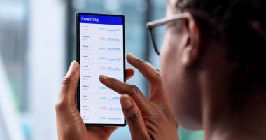 Genç Kadın Borsacı Mobil Uygulamayı Kullanarak Finansal Borsada Ticaret Yapıyor.