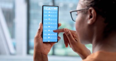 Meteorolog Olarak Çalışan Kadın Akıllı Telefon Uygulamasında İklim Tahminlerini Denetliyor.