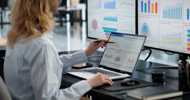 Ofis Kontrol Paneli üzerindeki Mali Verileri Uzman Analizi Yapan Kadın Dizüstü bilgisayar Kullanıyor.