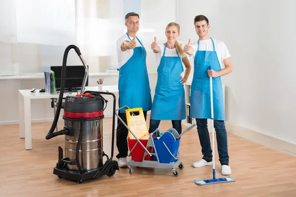 Janitors com aspirador de pó e equipamentos de limpeza — Fotografia de Stock