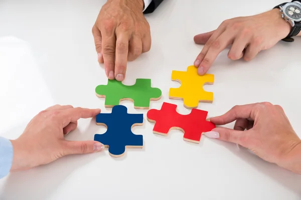 Les gens assemblant des pièces de puzzle — Photo