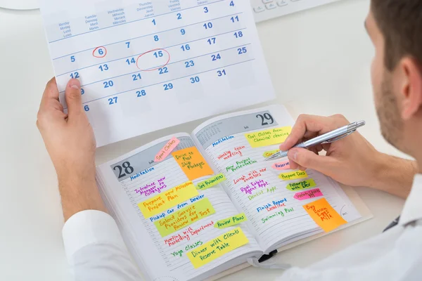 Uomo d'affari con calendario e diario — Foto Stock