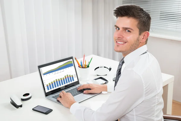 Businessman Working With Graph On Laptop At Desk — Stock Photo, Image