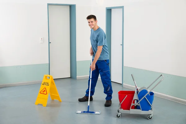 Männliche Arbeiter mit Reinigungsgeräten wischen Boden — Stockfoto