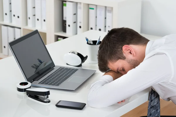 Empresario con computadora portátil durmiendo en el escritorio — Foto de Stock