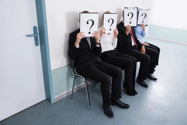 Empresarios escondidos detrás de signo de signo de interrogación — Foto de Stock