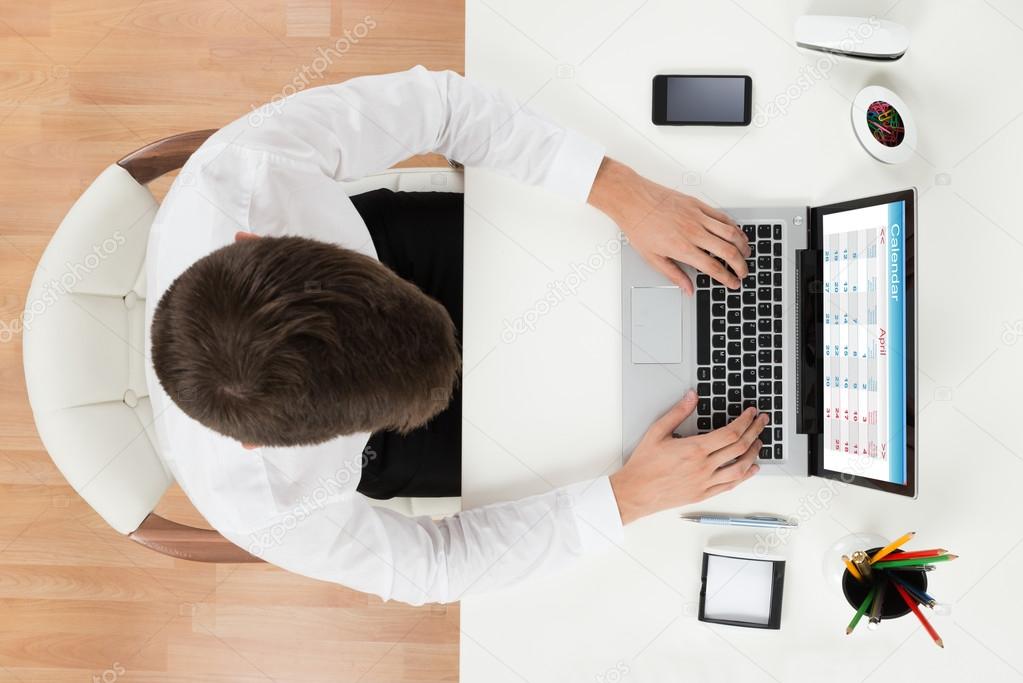 Young Businessman Looking At Calendar On Computer