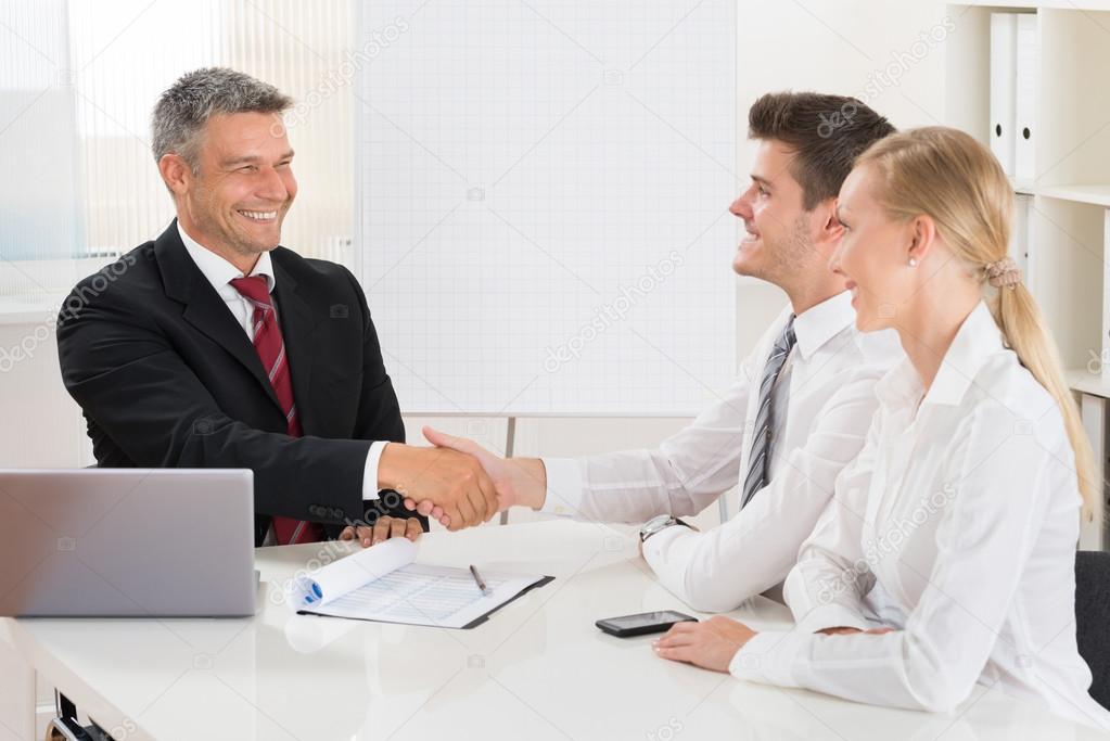 Estate Agent Shaking Hands With Couple