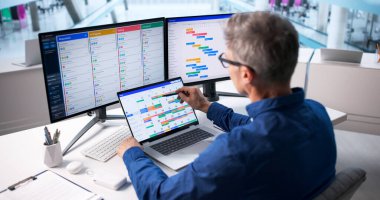 Older Caucasian Man Manages Business Event Scheduling Software On Desktop.