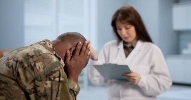 Soldier And Doctor Sit Together, Discussing Therapy And Mental Health Support. They Could Be Sharing Advice On PTSD
