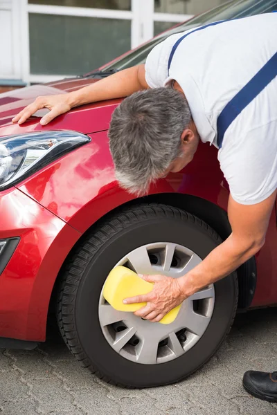 Handyman limpeza roda de carro com esponja — Fotografia de Stock