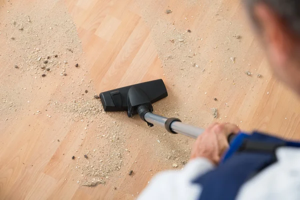 Hausmeister reinigt Boden mit Staubsauger — Stockfoto