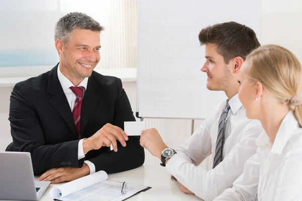 Consultor dando tarjeta de visita a pareja — Foto de Stock