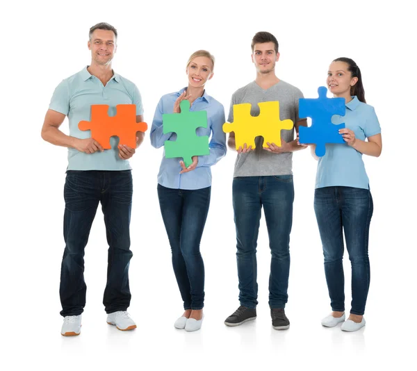 Glückliche Menschen mit Puzzleteilen — Stockfoto