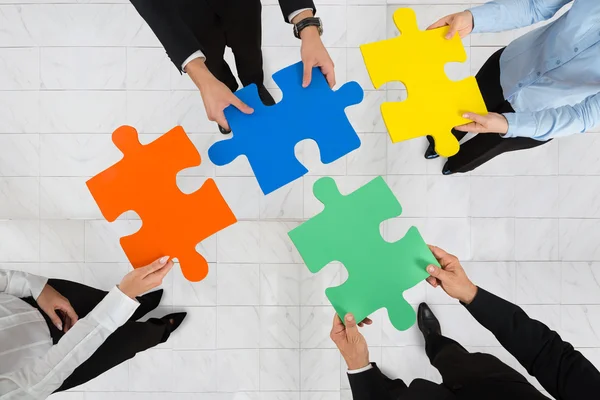 Businesspeople Holding Puzzle Pieces — Stock Photo, Image