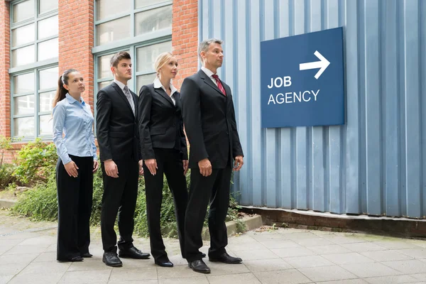 Les hommes d'affaires en attente dans une rangée — Photo